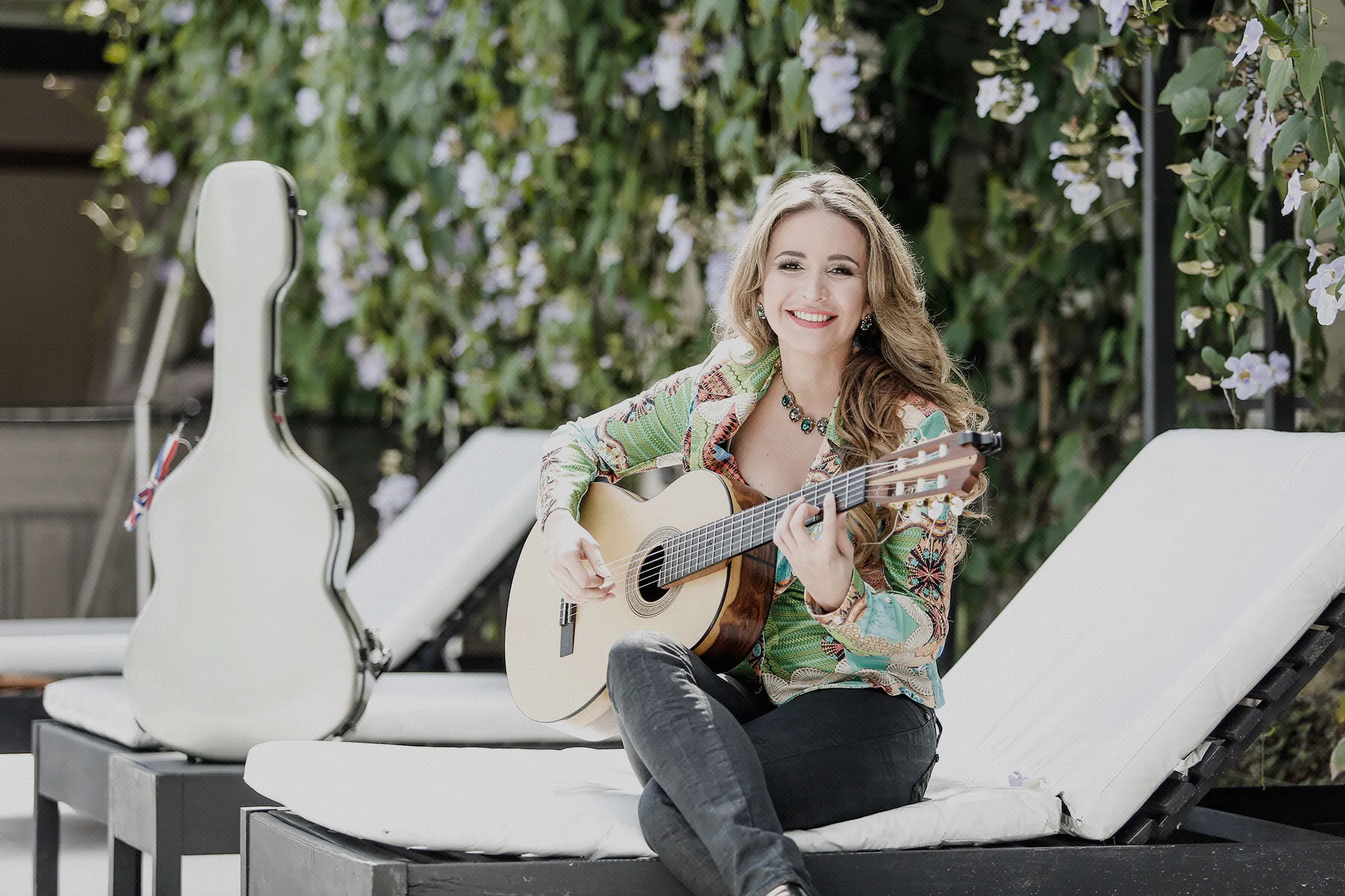 Daiana con su guitarra en una reposera, estuche blanco al lado